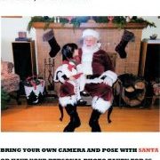 A child sits on Santa’s lap in a living room setting. A sign above advertises Santa photos on Friday, December 16th from 4PM to 7PM, including pricing and additional photo details.